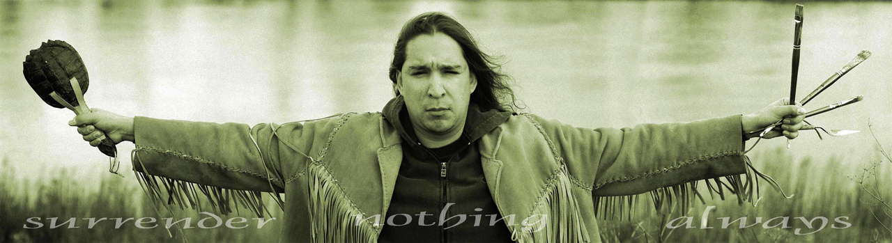 artist in fringe jacket with outstretched arms holding turtle rattle and paint brushes