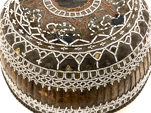 Decorative circular box with intricate silver and colorful designs.