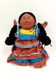 Handmade cloth doll with braided hair, black shawl, yellow bodice and orange-blue ruffled dress
